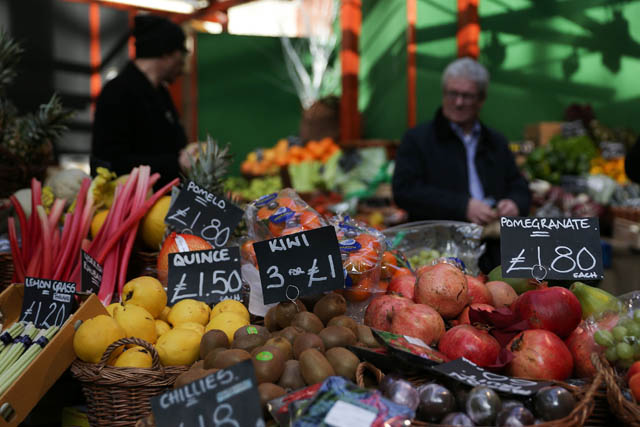 This photo taken on February 14 shows signs displaying the price in pounds sterling of fruit and vegetables at a food stall in a street market in southeast London (AFP photo)